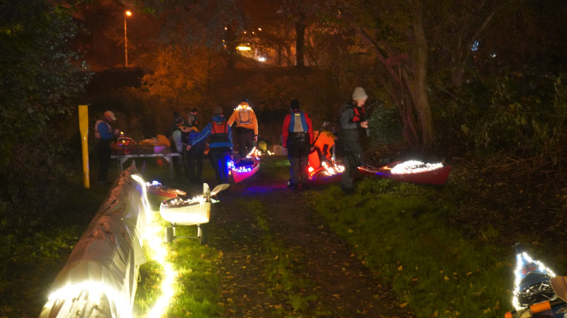 Teilnehmende beleuchten ihre Boote für die Lichterfahrt