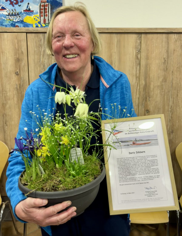 Doris Dibbern als Ehrenvorsitzende mit Blumen und einer Urkunde<br />
