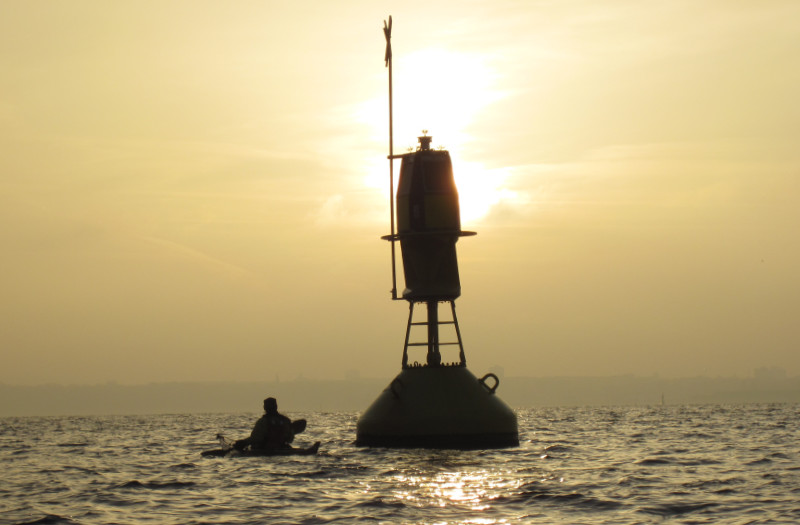 Seekajak vor einer Tonne bei einem diffusen Licht in der Abenddämmerung<br />
